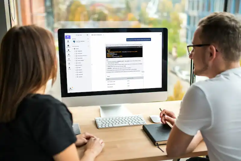 Two persons in front of a computer screen